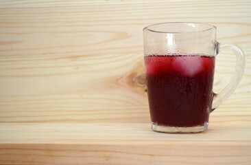 Currant compote with ice on a wood background