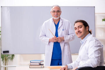Experienced doctor teaching young male assistant