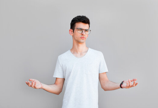 Closeup portrait of dumb clueless young man, arms out asking what's the problem who cares so what, I don't know. Isolated on white background. Negative human emotion, facial expressions, attitude