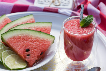 Watermelon smoothie garnished with fresh mint leaves - refreshing drink ideal for hot summer days.