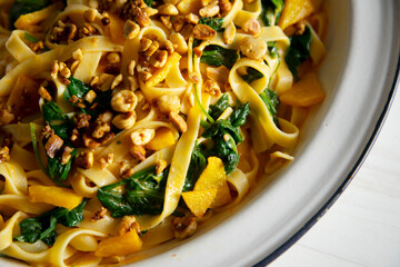 Vegan pasta with spinach, nuts and tomato sauce