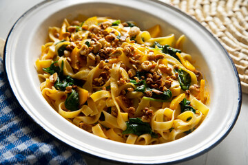 Vegan pasta with spinach, nuts and tomato sauce