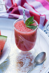 Watermelon smoothie garnished with fresh mint leaves - refreshing drink ideal for hot summer days.