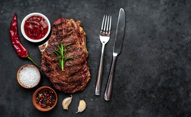 Marbled beef steak grill with spices on a stone background with copy space for your text

