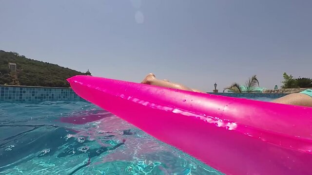 the girl on a rubber mattress in the pool, the camera then dives