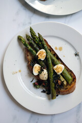 Fresh soughdough toast with quail eggs and seasonal asparagus