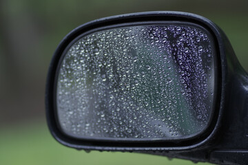 Side mirror of a car with drops from rain