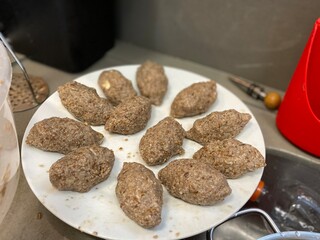 Arabian food. Meat. White plate. Preparing Kibes.