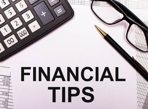 FINANCIAL ADVICE is written on a white sheet between the glasses in black right, pen and calculator. Financial concept