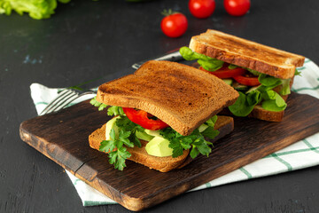 Healthy sandwich with vegetables on dark wooden background