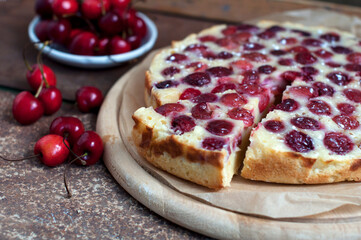 Tart with ripe sweet cherries and green tea on brown background. Homemade dessert with ripe sweet cherries.