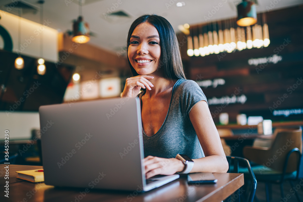 Poster portrait of smiling successful freelancer enjoying free schedule and remote job spending time in caf