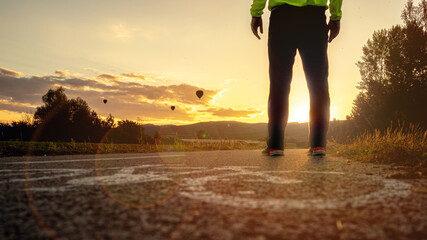 close up of bike traffic sign on concrete sunset cyclo way with a man silhouette standing on the road