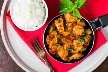 Chicken, tomato and zucchini sauce served with rice.