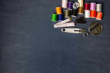 Hight view Sewing tools group and spools of thread on gray paper backdrop