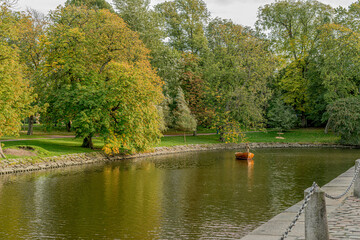 Person standing in a wooden boat fishing in the canals in the city center