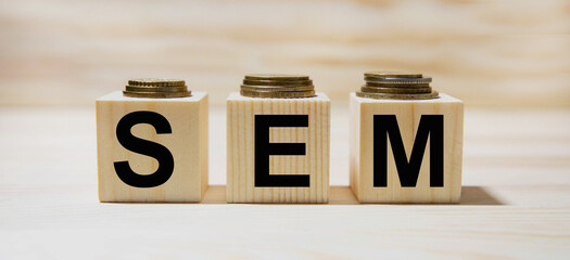 Search Engine Marketing, SEM written on a wooden cube in a office desk