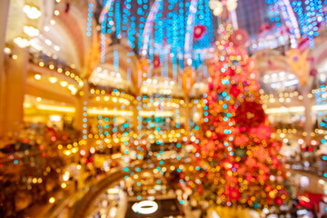Bright out of focus generic shopping mall with Christmas tree lights and falling confetti background