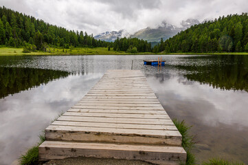 Fototapeta premium St.Moritz, Stazersee, górskie jezioro, Stazerwald, drewniana kładka, jezioro kąpielowe, zabawa w kąpieliskach, Engadyna, Górna Engadyna, Alpy, Piz Nair, Piz Julier, Gryzonia, lato, Szwajcaria