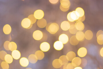 background of burning light bulbs, yellow lights in focus on a soft white background, festive mood