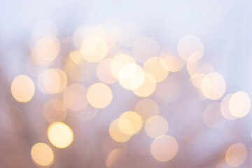 background of burning light bulbs, yellow lights in focus on a soft white background, festive mood