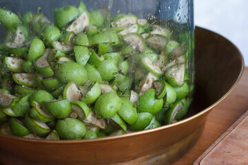 Step-by-step recipe for preparing Italian liquor nocino from green walnuts at home, real home kitchen and cooking, selective focus