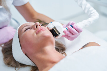 Obraz na płótnie Canvas Adult woman in beauty salon undergoing face hydrogen purification