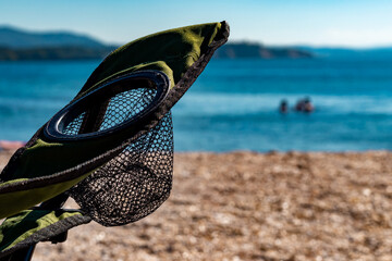 close up green camping chair details and cup holders. beach, sea and sky view