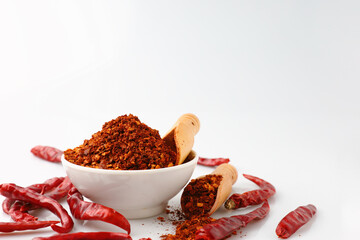 Cayenne pepper in a white cup with many red dried chilies.