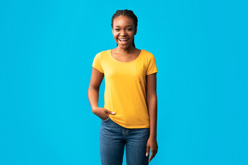 Positive African Girl In Braces Standing In Studio, Blue Background