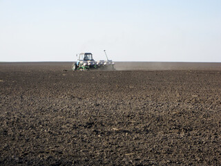 Plowed field by tractor in brown soil on open countryside nature