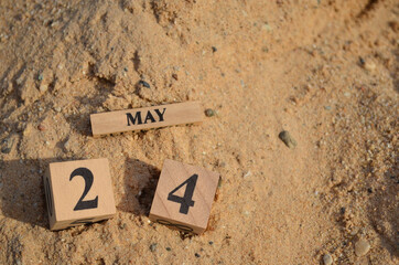 May 24, Number cube with Sand pile for a background.