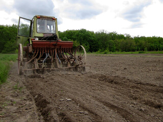 Plowed field by tractor in brown soil on open countryside nature