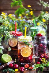 Healthy homemade cold lemonade with fresh berries and fruits in mason jar