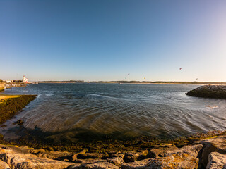 People practicing kitesurf. Kitesurfers on the mouth of the Cavado River in Esposende, Portugal. Esposende it's renowned by kite-surfers as one of the best places to kitesurf.