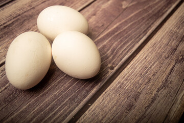 White chicken eggs on a wooden background. Close up.