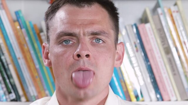 Articulatory exercise biting the tongue. A man does a speech apparatus training before speaking in an audience. Improving the diction of the lead.