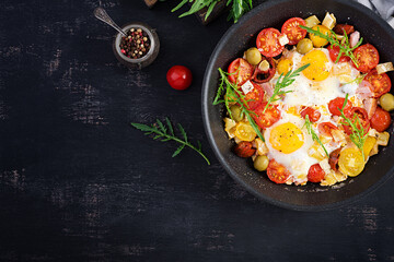 English breakfast - fried eggs, ham, tomatoes and arugula. American food. Top view, overhead, copy space