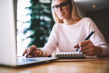 Selective focus on hipster girl writing interesting ideas for scenario for school performance while...