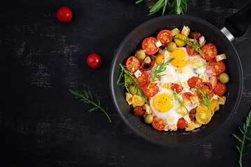 English breakfast - fried eggs, ham, tomatoes and arugula. American food. Top view, overhead, copy space