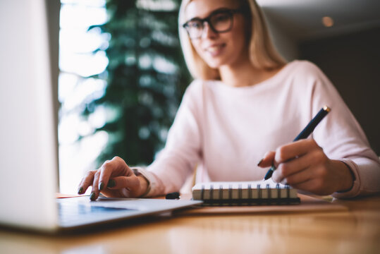 Selective focus on hipster girl writing interesting ideas for scenario for school performance while making research on content websites, woman typing text message via laptop keyboard for send reply