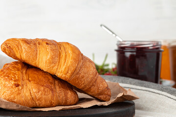 Fresh baked croissant on wooden table close up