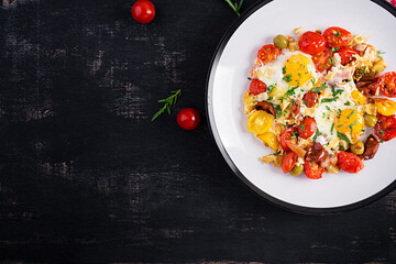 English breakfast - fried eggs, ham, tomatoes and arugula. American food. Top view, overhead, copy space
