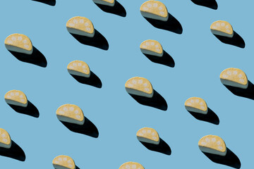 Pattern of tasty marshmallows with hard shadows on a light blue background.