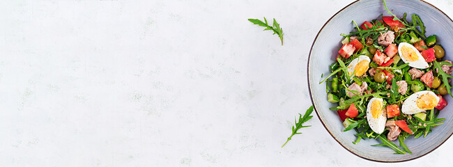 Healthy food. Tuna fish salad with eggs, cucumber, tomatoes, olives and arugula.  French cuisine. Top view, copy space, banner