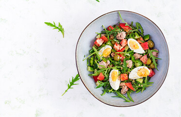 Healthy food. Tuna fish salad with eggs, cucumber, tomatoes, olives and arugula.  French cuisine. Top view, copy space, flat lay