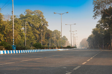 Fototapeta na wymiar View of empty Red Road in the morning with blue sky above. Image shot at Kolkata, West Bengal, India.