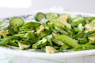 healthy, summer salad of avocado, cucumber, sugar pea pods
