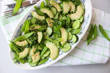 healthy, summer salad of avocado, cucumber, sugar pea pods