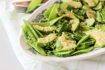 healthy, summer salad of avocado, cucumber, sugar pea pods